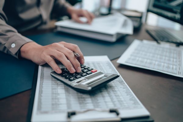 Investor using a calculator on their desk