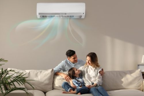 family resting under air conditioner Family Under Air Conditioning Unit
