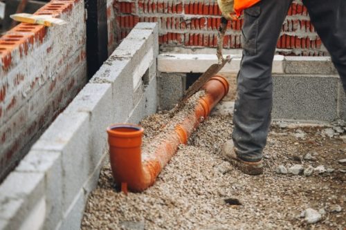Construction worker laying drainage pipe Groundwork Construction Worker