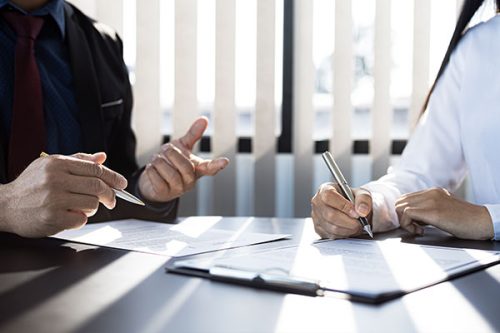 An insurance provider and a client are signing an insurance agreement, accepting the terms and benefits.
