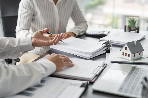 discussing contractors all risk insurance in brokers office, paperwork on desk